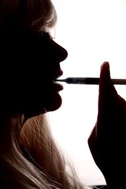 Frau raucht eine Zigarette – Zigarettenrauch verursacht hartnäckige Nikotingerüche und Geruchsbelastungen in Innenräumen.